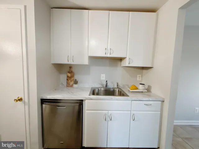 a kitchen with white cabinets and a sink