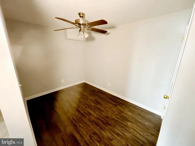 a view of room with wooden floor and ceiling fan