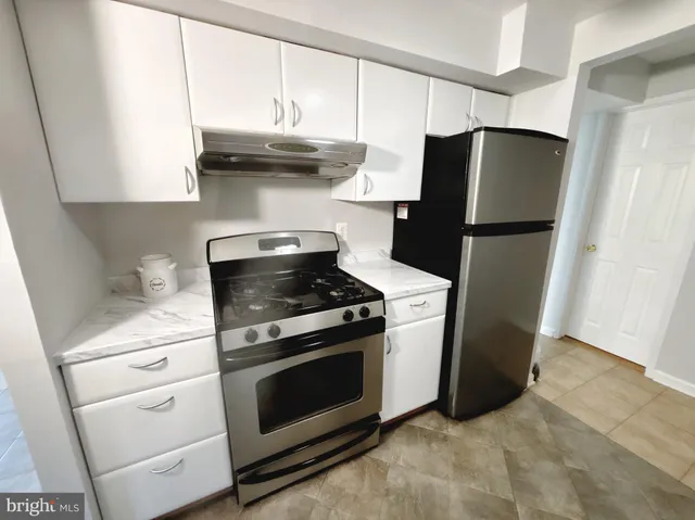 a kitchen with stainless steel appliances wooden floor sink and refrigerator