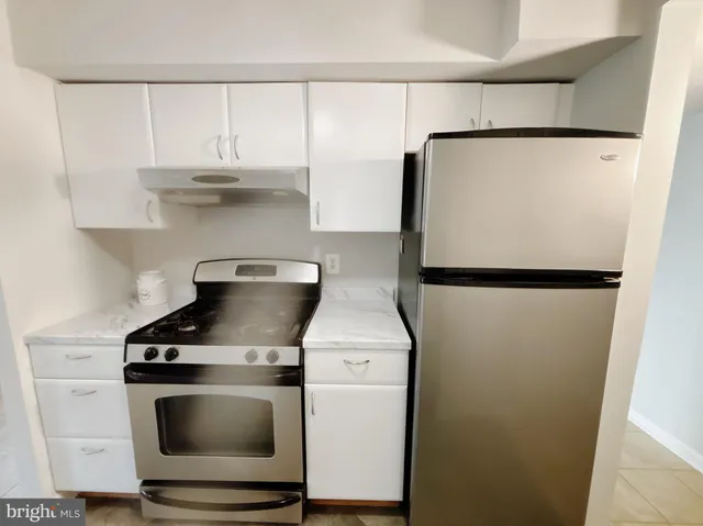 a stove top oven sitting inside of a kitchen