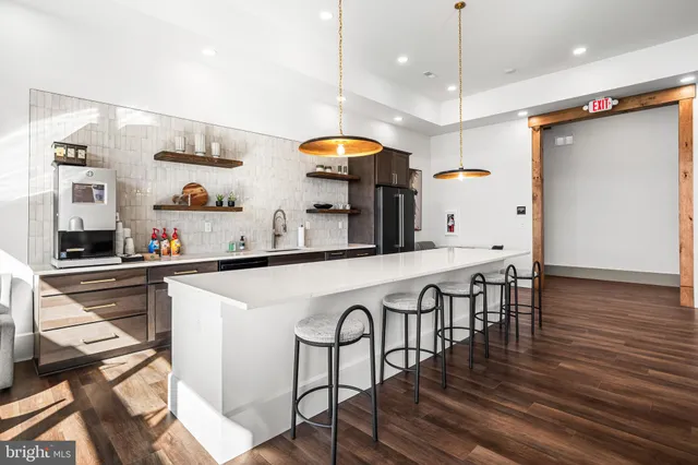a kitchen with stainless steel appliances granite countertop a table chairs sink and wooden floor