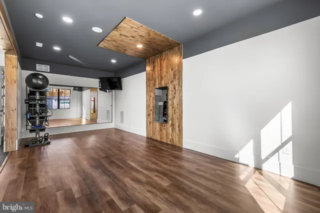a view of empty room with wooden floor and window