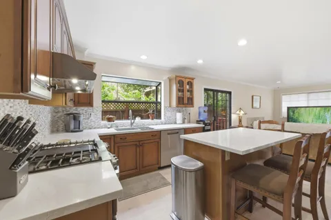 a kitchen with a stove a sink dishwasher and a refrigerator