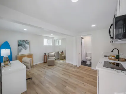 a room with furniture a flat screen tv and a refrigerator