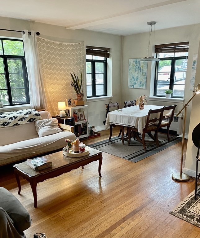 a living room with furniture a window and wooden floor