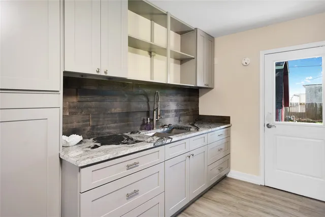 a kitchen with granite countertop white cabinets and white appliances