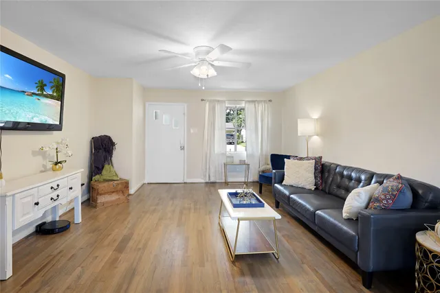 a living room with furniture and wooden floor