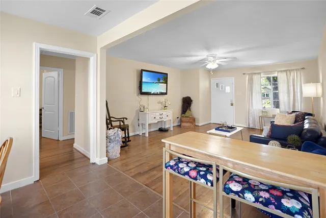 a living room with furniture a dining table and a chandelier