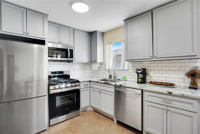 a kitchen with cabinets stainless steel appliances a sink and a counter space
