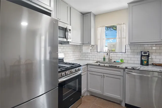 a kitchen with stainless steel appliances a sink stove and refrigerator