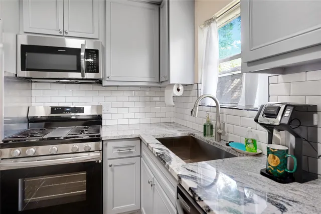 a kitchen with a stove a microwave and a sink