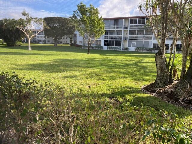 266 Brighton G, Unit 266 Boca Raton, FL 33434 - Photo 14 of 15 a view of a large building with a big yard and large trees