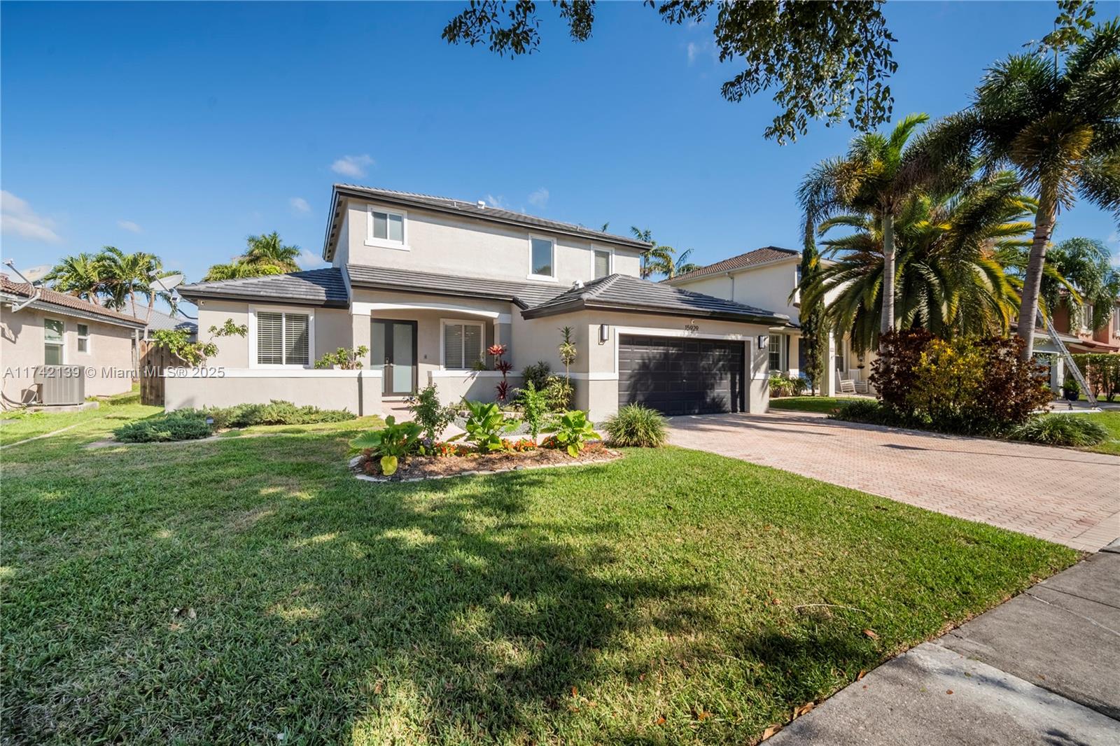 15929 Southwest 141st Terrace Miami, FL 33196 - Photo 1 of 41 a front view of a house with garden and porch