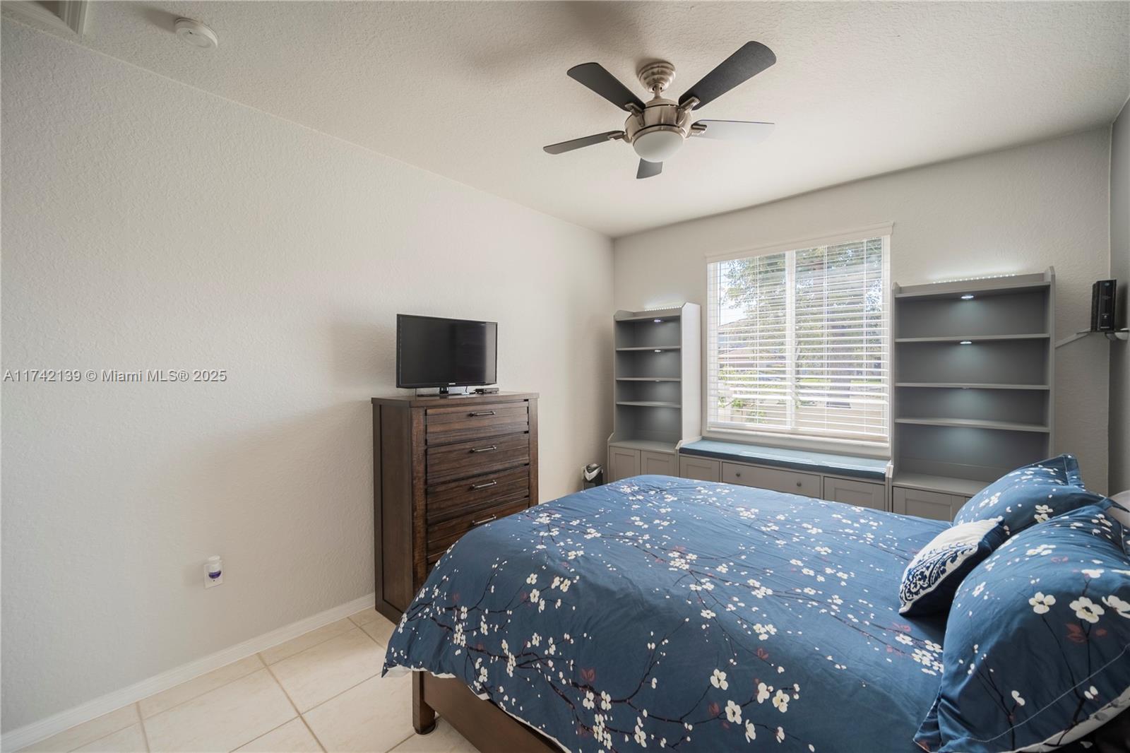 15929 Southwest 141st Terrace Miami, FL 33196 - Photo 14 of 41 a bedroom with a bed and a television