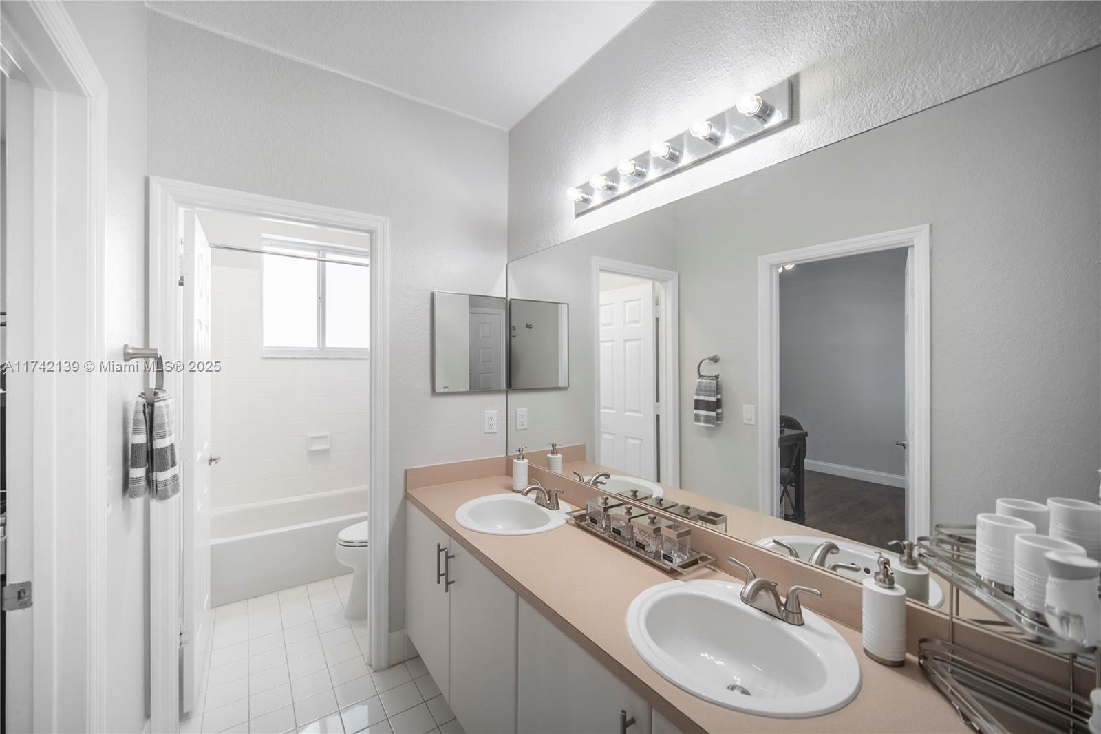 15929 Southwest 141st Terrace Miami, FL 33196 - Photo 33 of 41 a bathroom with a sink double vanity and a mirror