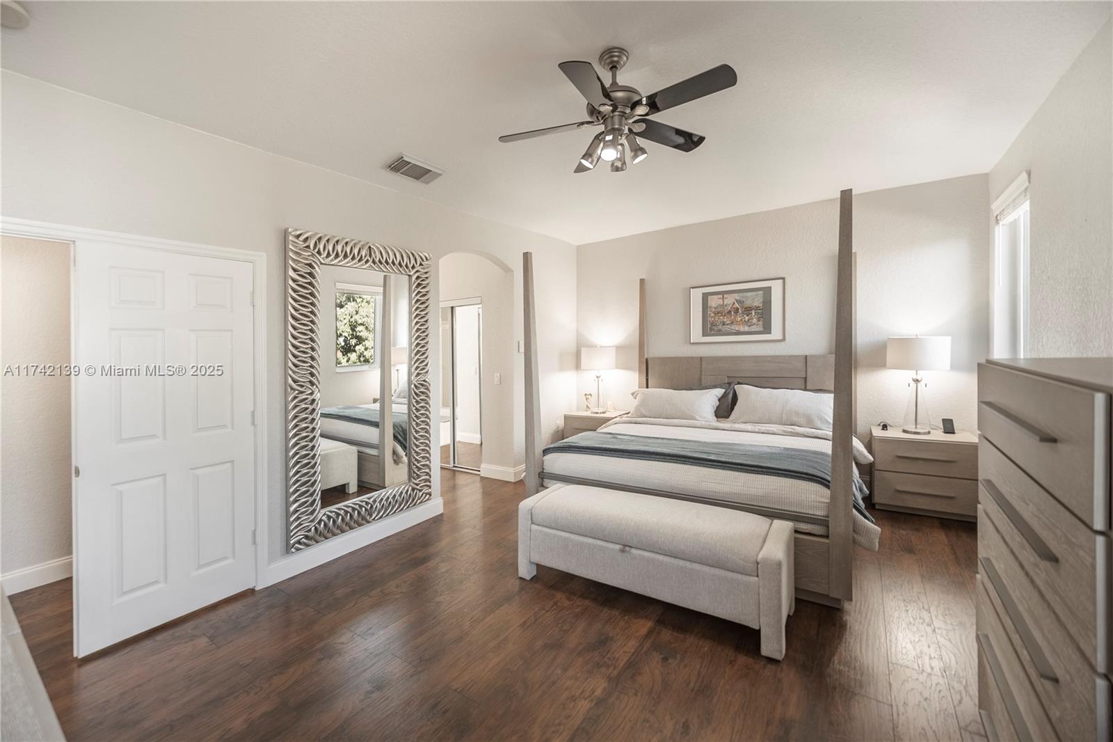 15929 Southwest 141st Terrace Miami, FL 33196 - Photo 38 of 41 a spacious bedroom with a bed and a chandelier