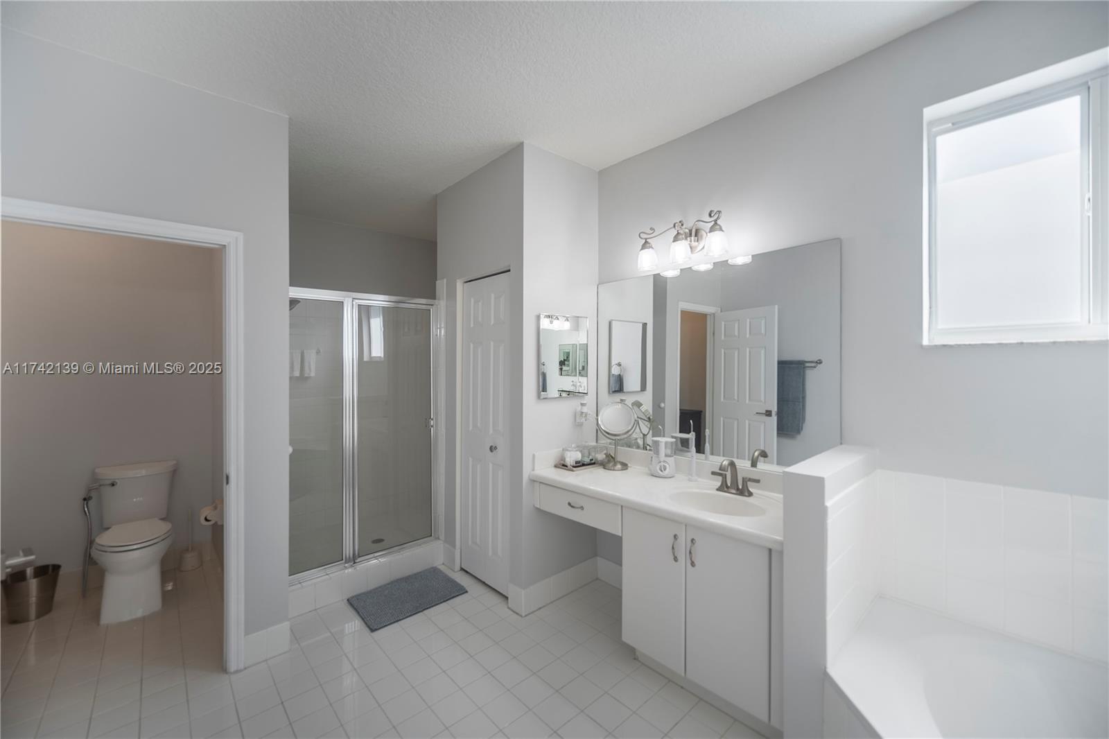 15929 Southwest 141st Terrace Miami, FL 33196 - Photo 40 of 41 a bathroom with a double vanity sink mirror and toilet
