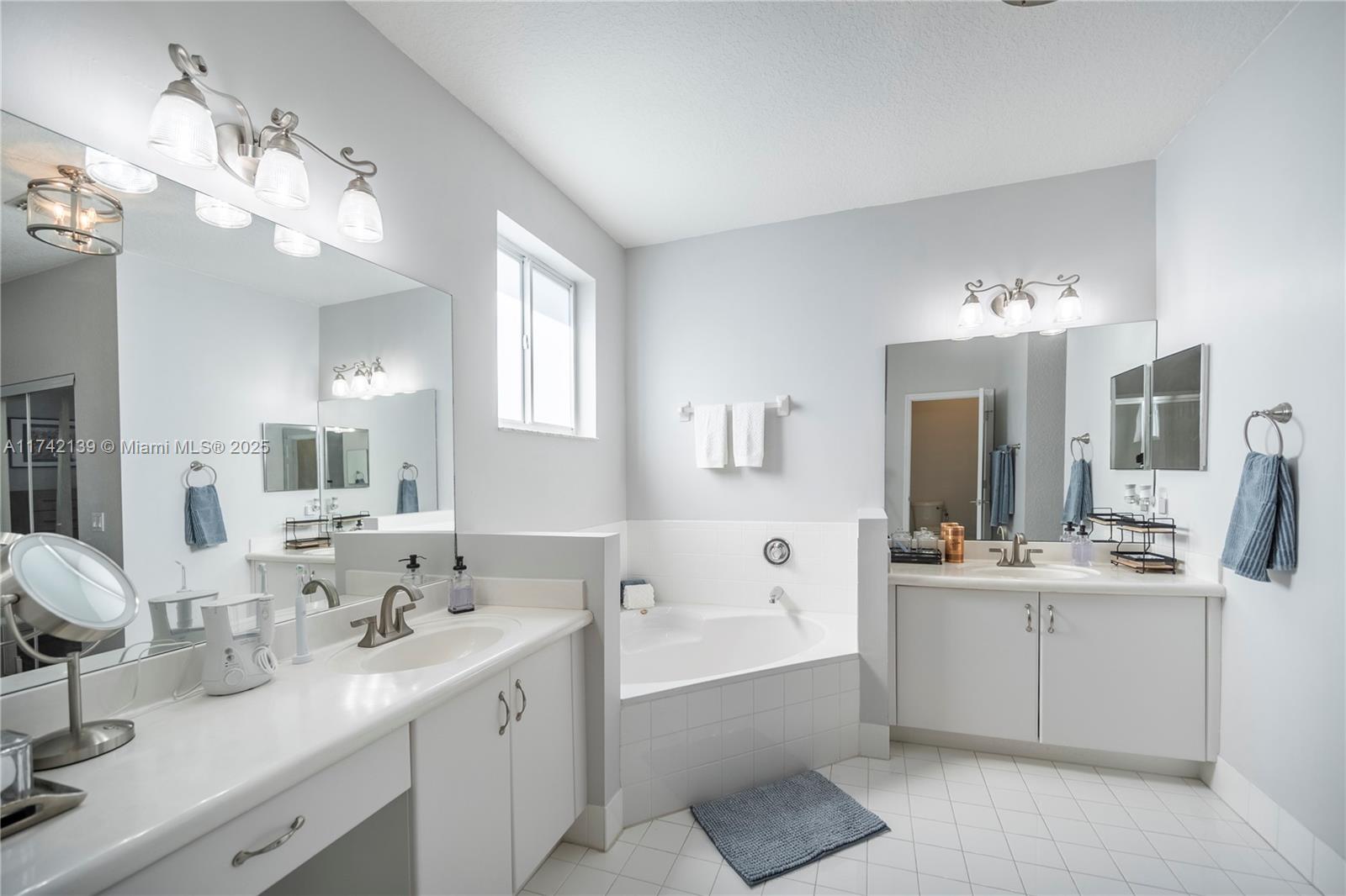 15929 Southwest 141st Terrace Miami, FL 33196 - Photo 41 of 41 a spacious bathroom with a sink a large mirror and a bathtub