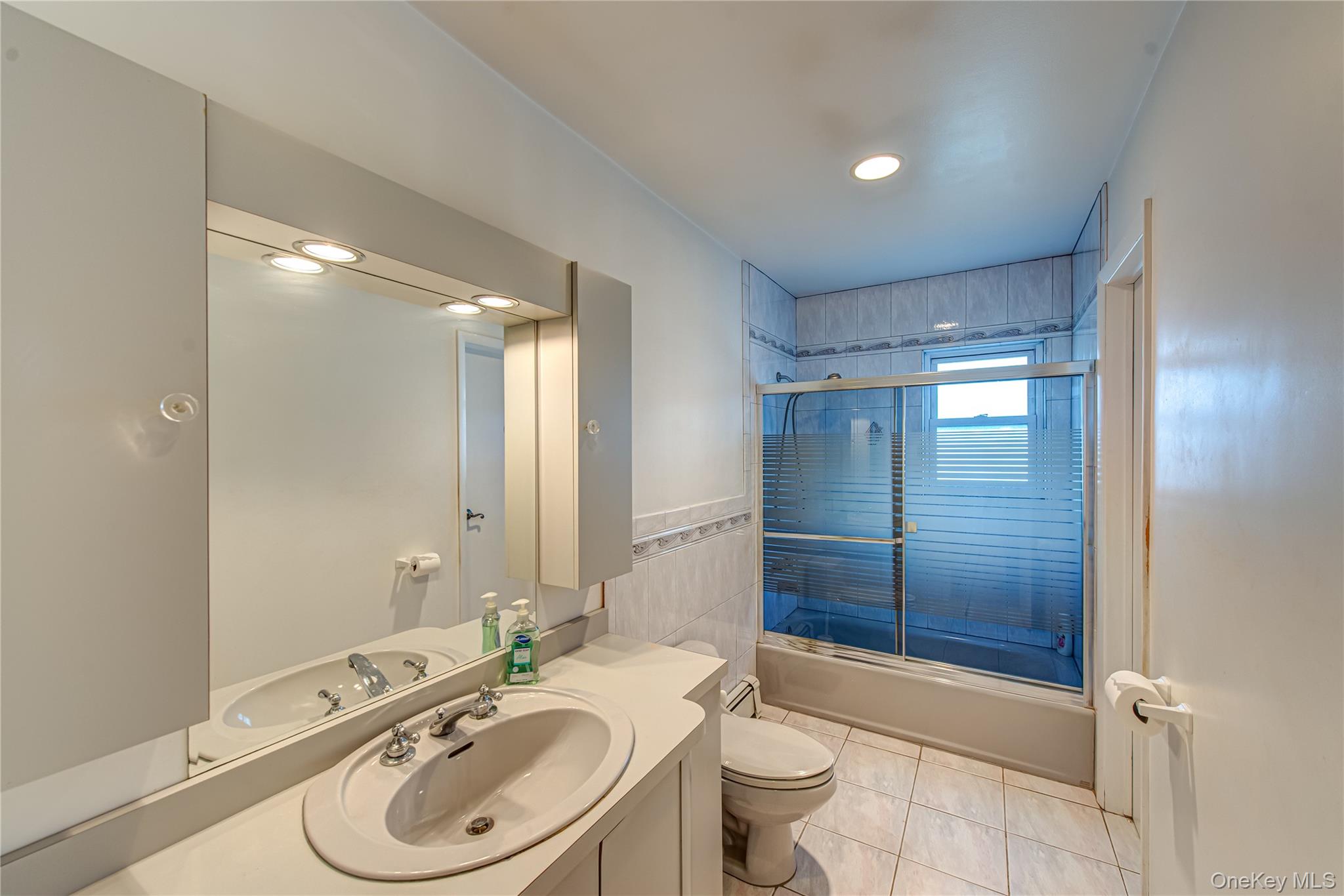 49 Spector Lane Plainview, NY 11803 - Photo 12 of 20 a bathroom with a sink a toilet and shower
