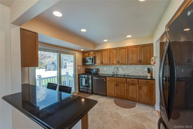 a kitchen with stainless steel appliances granite countertop a refrigerator and a stove top oven