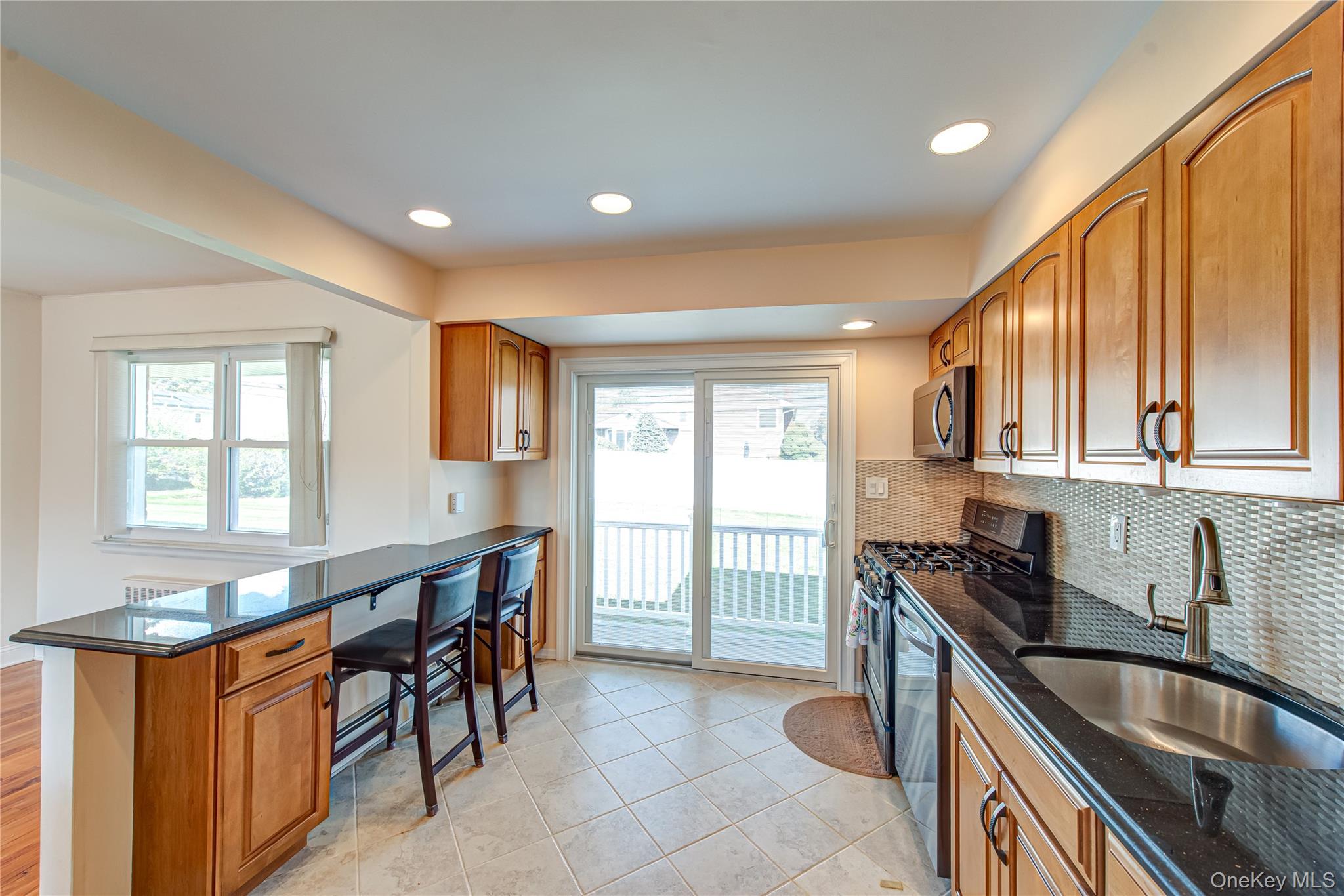 49 Spector Lane Plainview, NY 11803 - Photo 3 of 20 a kitchen with granite countertop a sink stove and cabinets