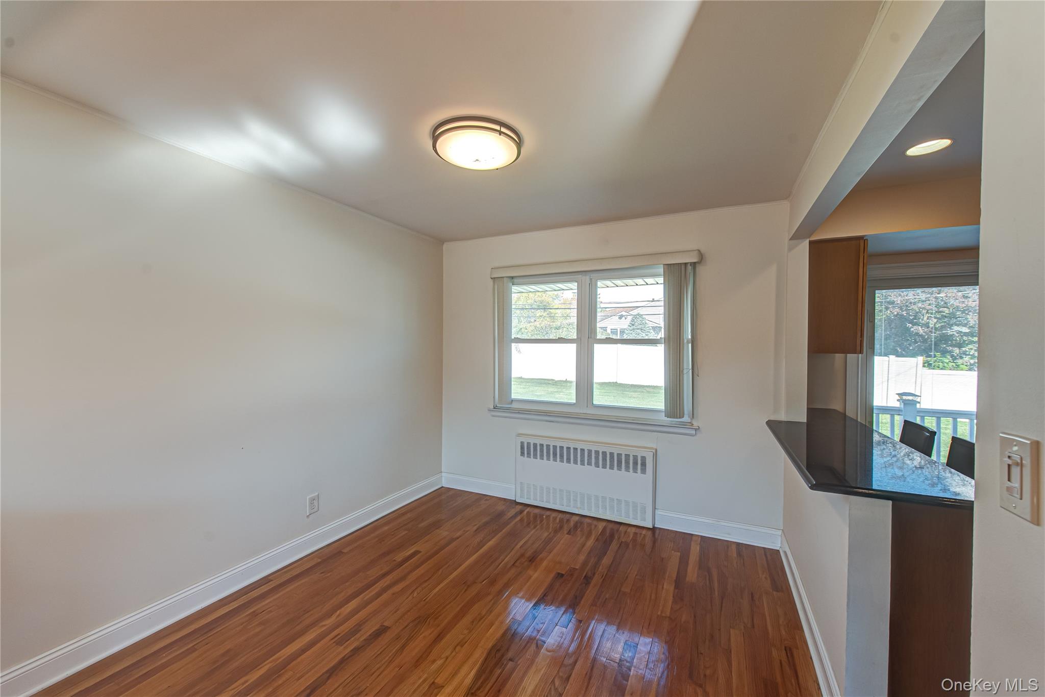 49 Spector Lane Plainview, NY 11803 - Photo 7 of 20 an empty room with wooden floor and windows