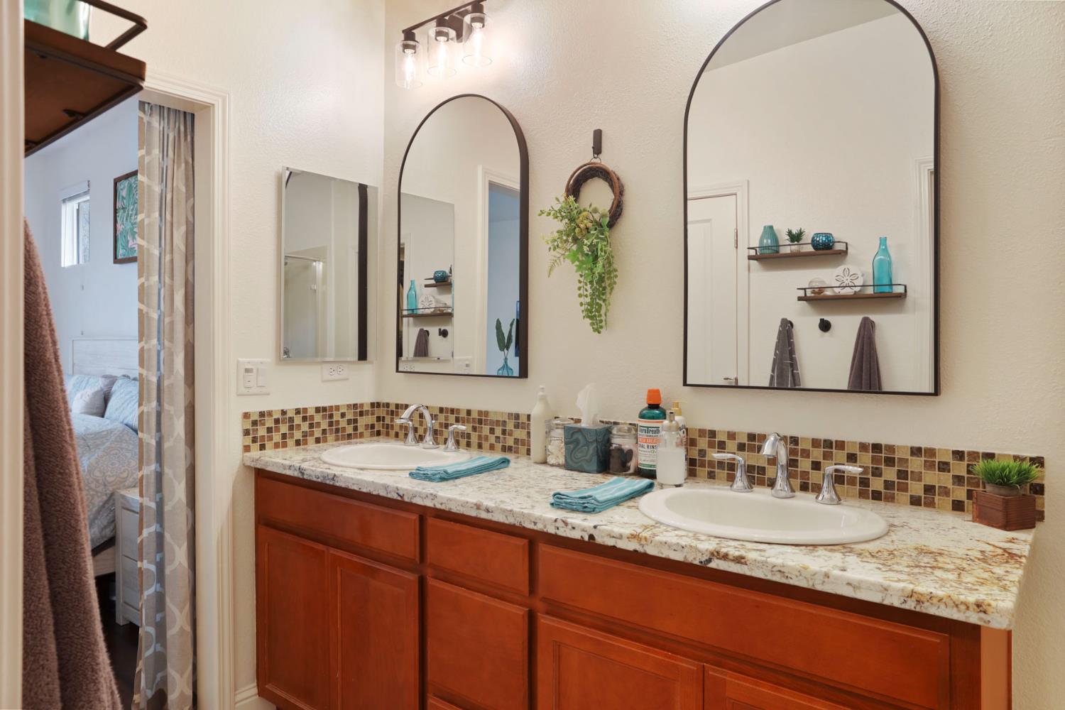 1091 Alba Street Manteca, CA 95337 - Photo 27 of 37 a bathroom with a granite countertop sink a mirror and a shower