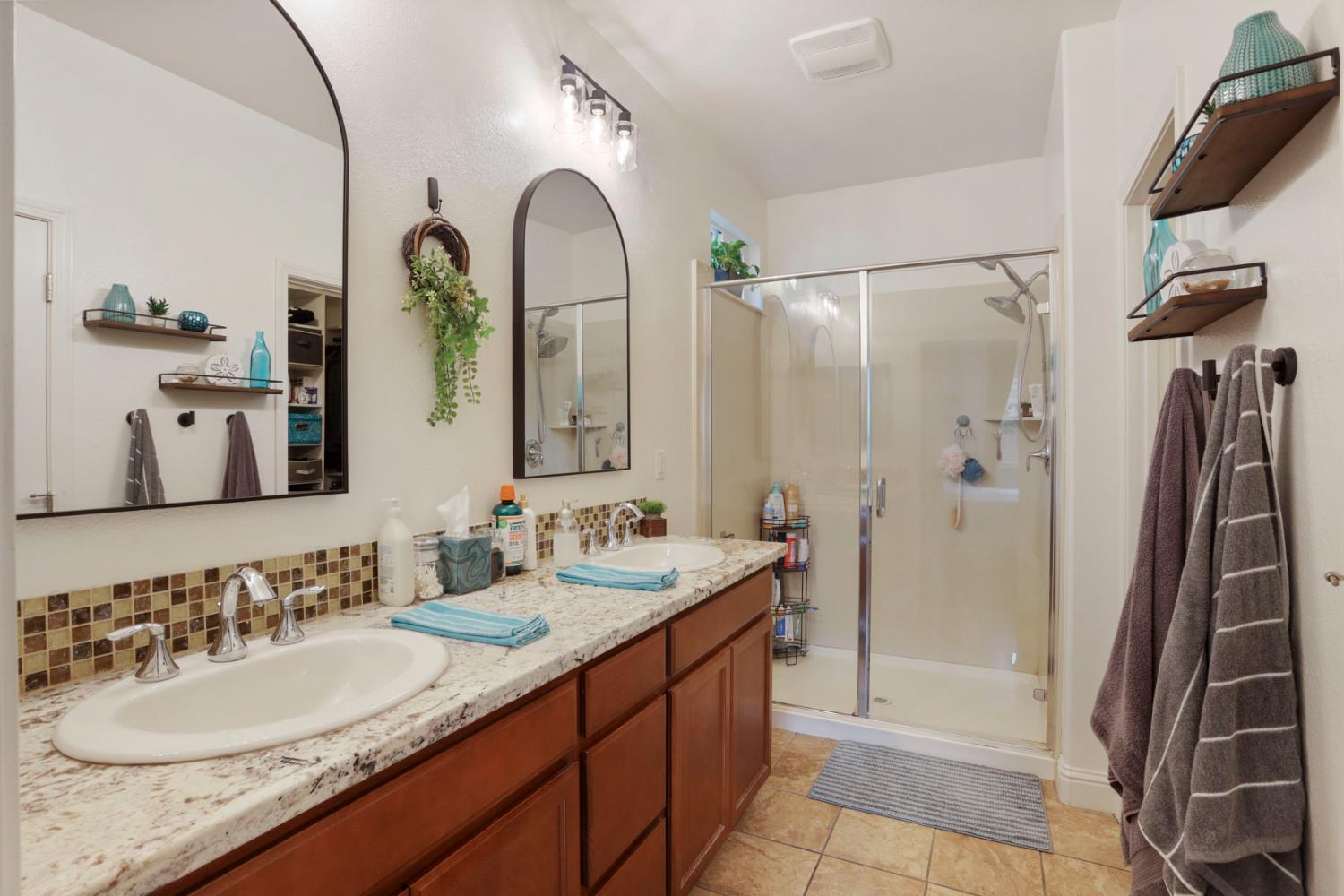 1091 Alba Street Manteca, CA 95337 - Photo 29 of 37 a bathroom with a granite countertop sink a mirror and shower