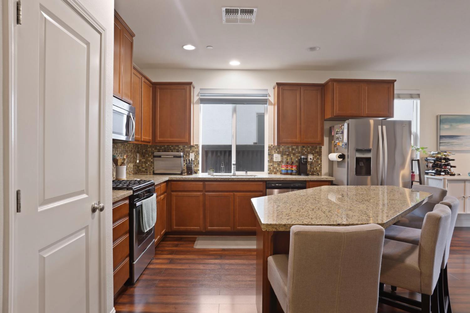 1091 Alba Street Manteca, CA 95337 - Photo 7 of 37 a kitchen with stainless steel appliances granite countertop a refrigerator a stove top oven a sink and dishwasher