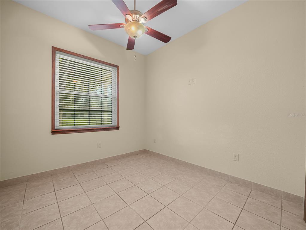 100 Reedy Creek Drive Frostproof, FL 33843 - Photo 18 of 36 an empty room with windows and fan