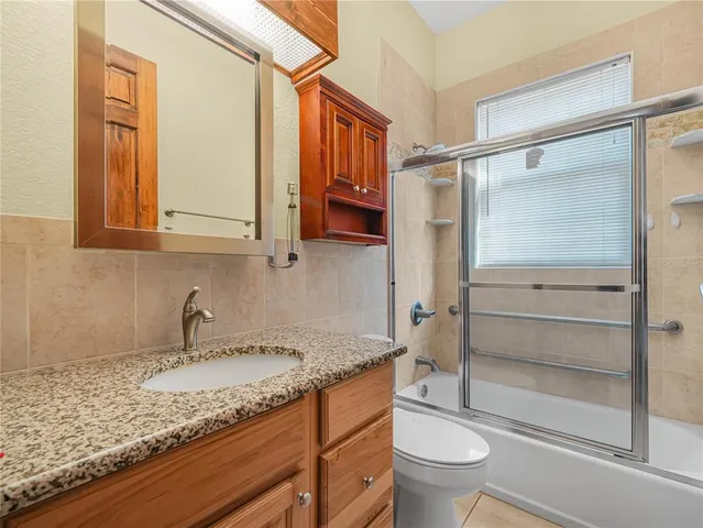 a bathroom with a granite countertop sink toilet and a mirror