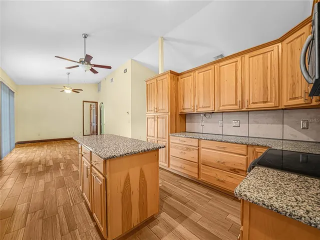 a kitchen with granite countertop a sink a counter top space and cabinets