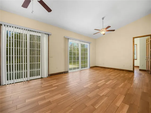 an empty room with ceiling fan and window