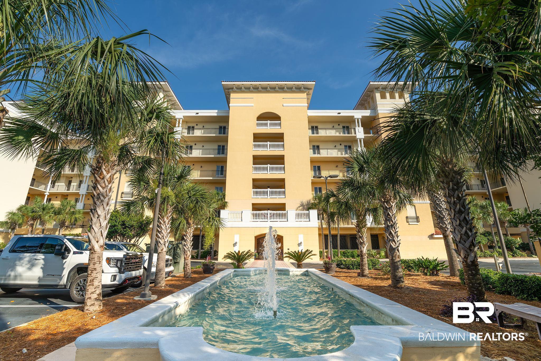 14500 River Road, Unit 305 Pensacola, FL 32507 - Photo 1 of 42 Multi-story building featuring a central arched entryway, individual balconies, and a light-toned exterior finish