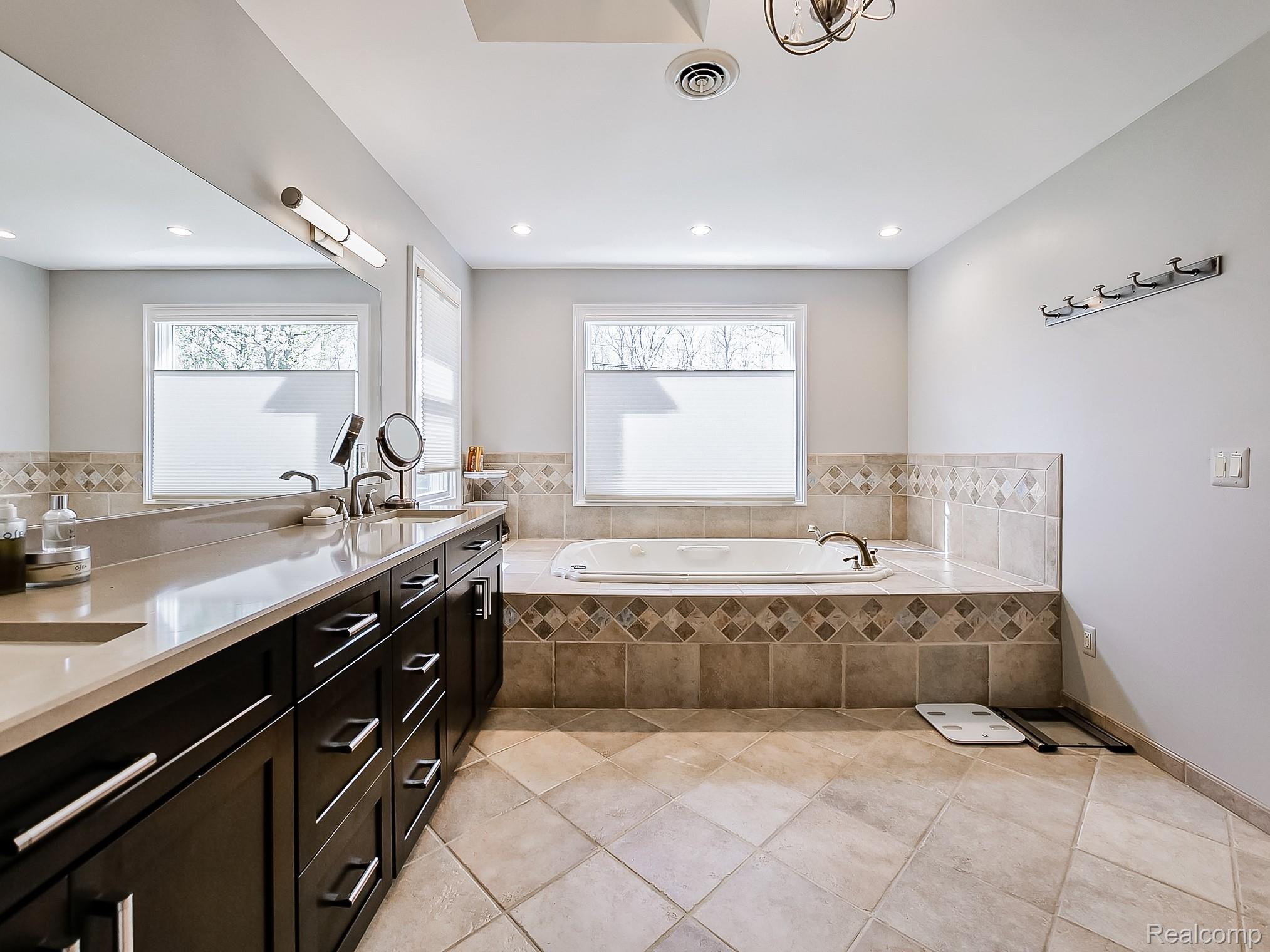 3720 East Clarkston Road Oakland, MI 48363 - Photo 21 of 60 Bathroom featuring a bath, double vanity, and light tile patterned floors