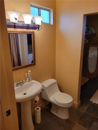 a bathroom with a toilet a sink and mirror
