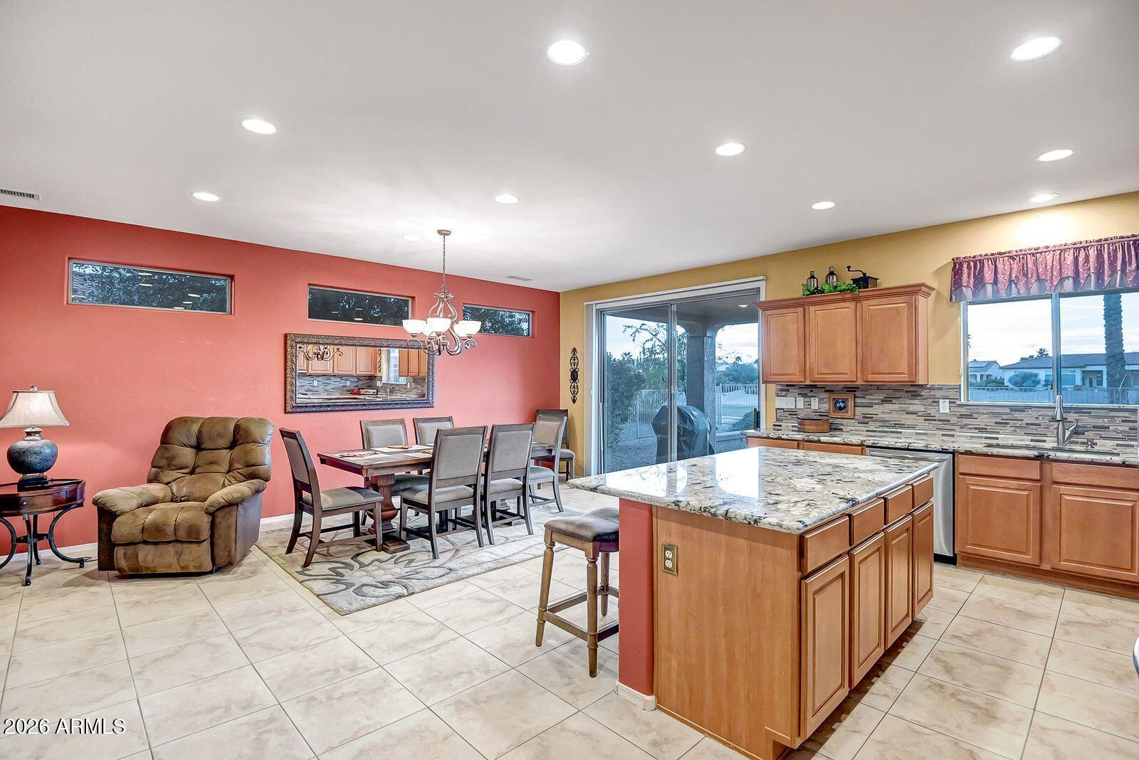 19848 North Rawhide Way Surprise, AZ 85387 - Photo 12 of 61 a kitchen with a stove a sink a counter top space and living room view