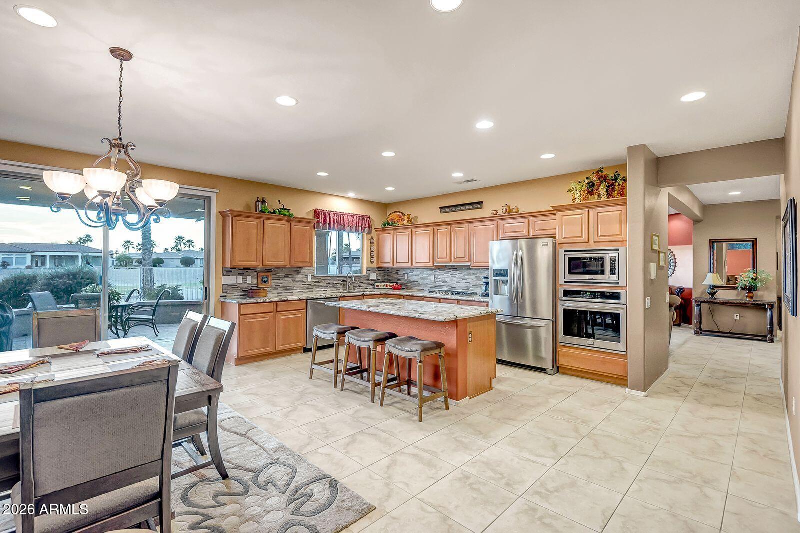 19848 North Rawhide Way Surprise, AZ 85387 - Photo 8 of 61 a kitchen with stainless steel appliances a stove a table and chairs