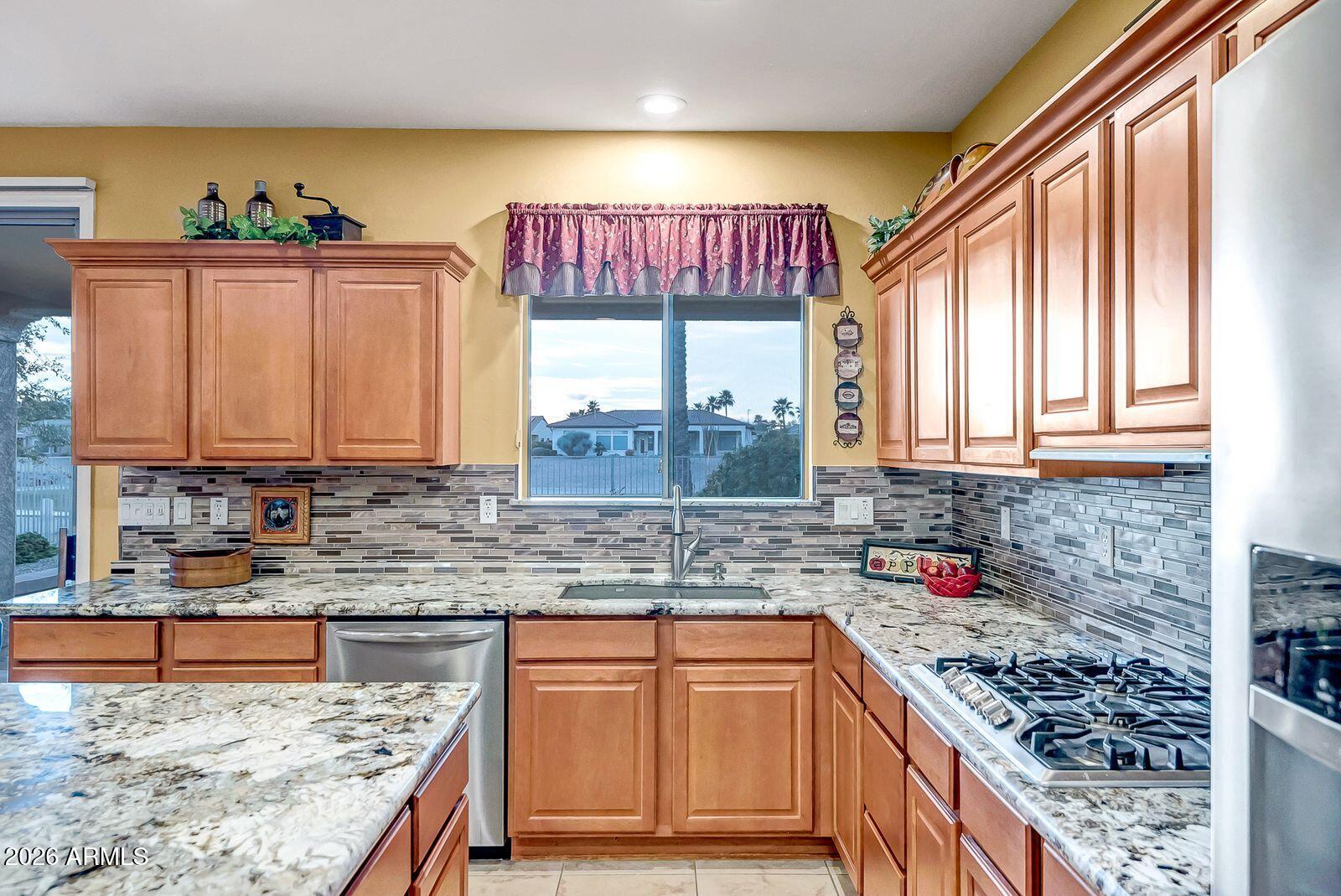 19848 North Rawhide Way Surprise, AZ 85387 - Photo 9 of 61 a kitchen with stainless steel appliances granite countertop a stove a sink and a microwave