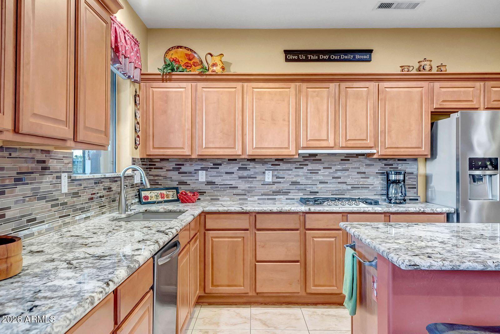 19848 North Rawhide Way Surprise, AZ 85387 - Photo 10 of 61 a kitchen with granite countertop a sink and a stove