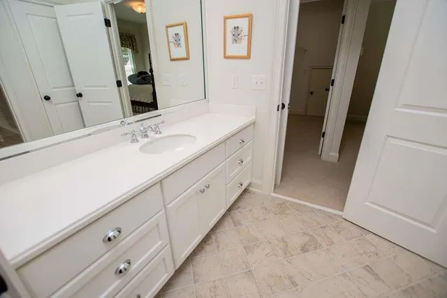 a bed sitting in a bedroom next to a white wall