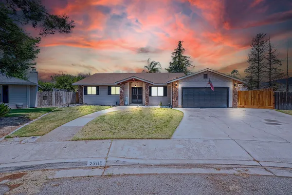 a view of a white house with a yard and large tree