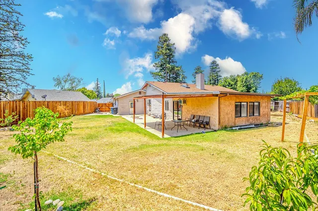 a backyard of a house with a fountain and plants