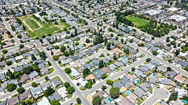 an aerial view of a residential houses with yard