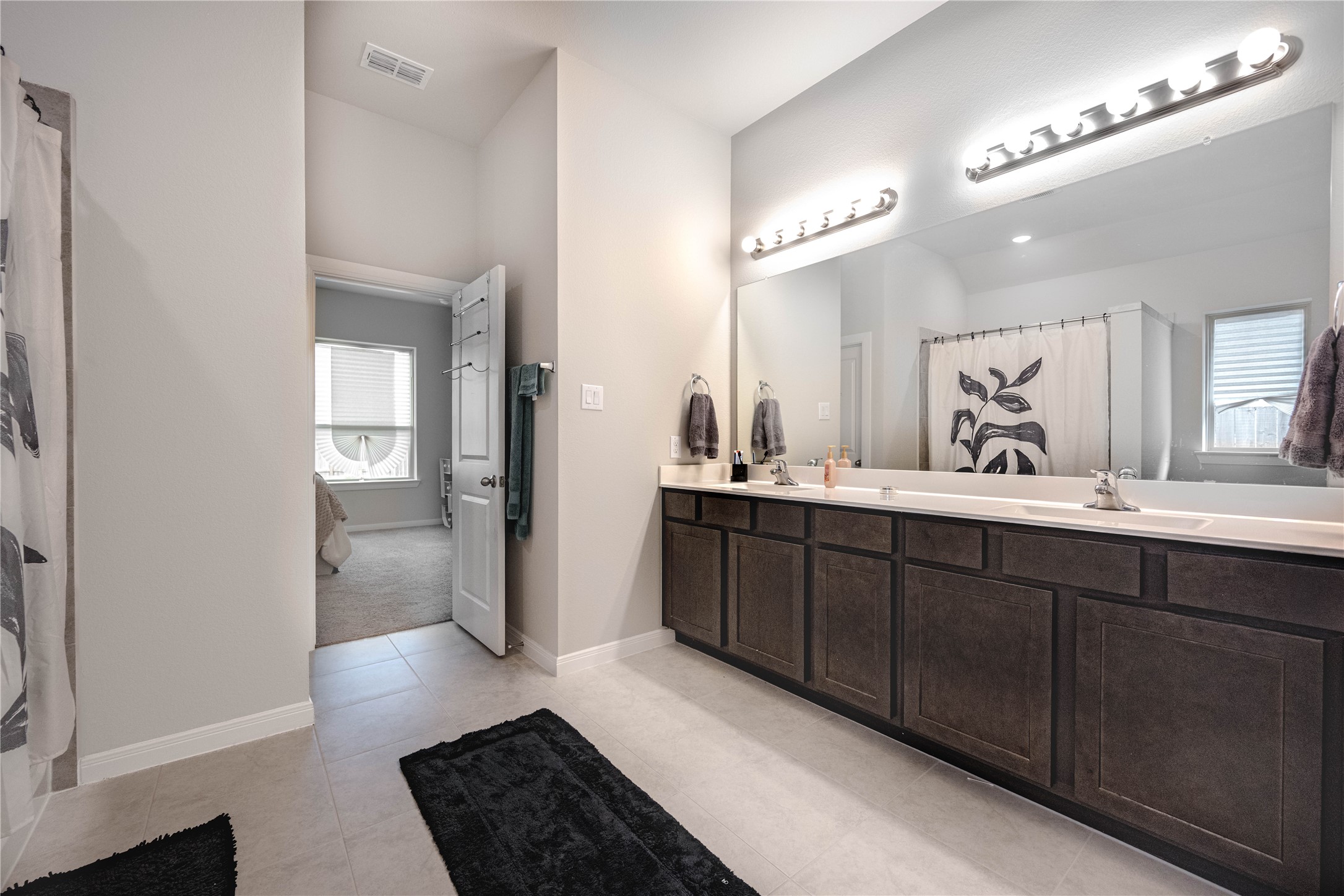 9026 Red Wolf Place Manvel, TX 77578 - Photo 11 of 17 a bathroom with a double vanity sink a mirror and a shower