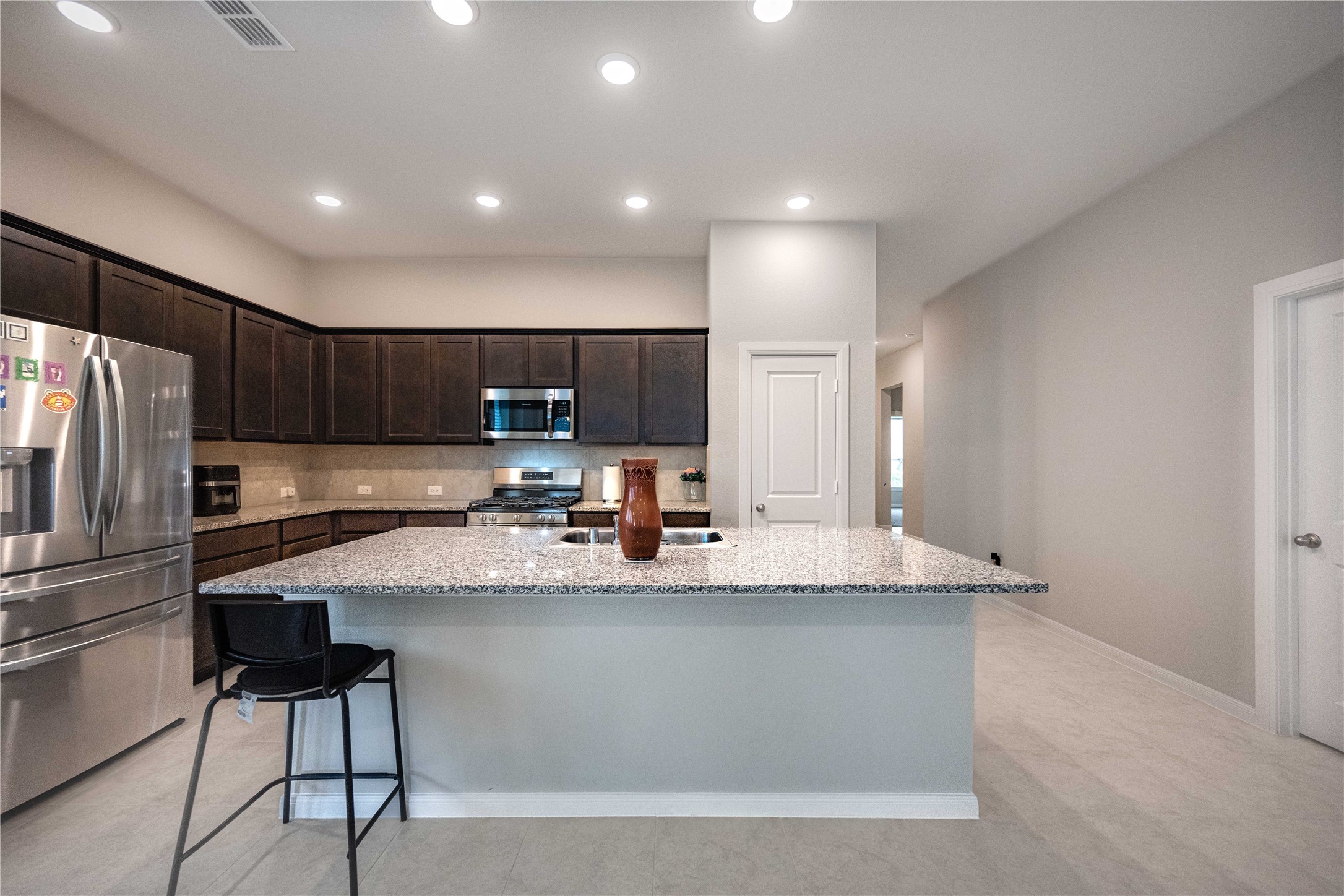 9026 Red Wolf Place Manvel, TX 77578 - Photo 6 of 17 a large kitchen with granite countertop a large counter top stainless steel appliances and cabinets