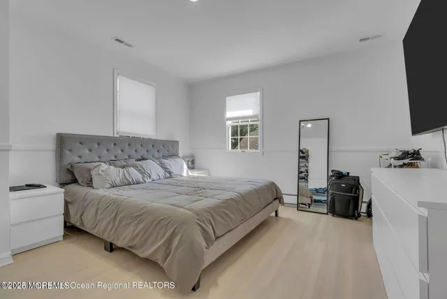 a bedroom with a bed and flat screen tv
