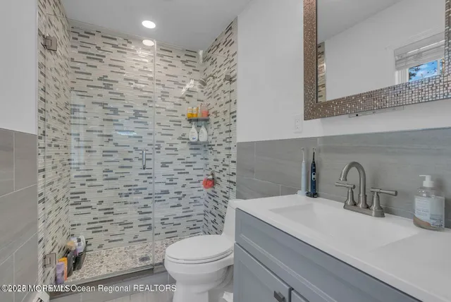 a bathroom with a granite countertop toilet a sink and a mirror
