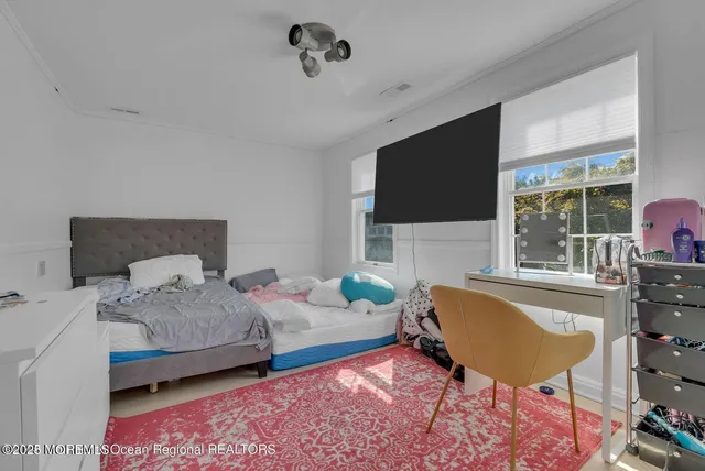 a bedroom with a bed a couch and large window