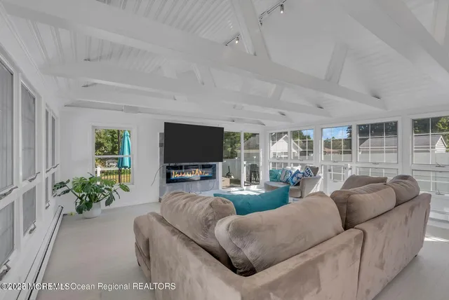 a living room with furniture a flat screen tv and a large window